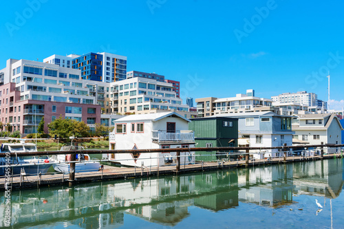 Houseboats on shallow water of Mission Creek Channel. Residential mid-rise and high-rise apartment buildings of Mission Bay district in San Francisco, California © MichaelVi