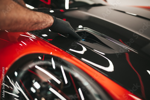 A man cleaning car, car detailing (or valeting) concept. Selective focus.