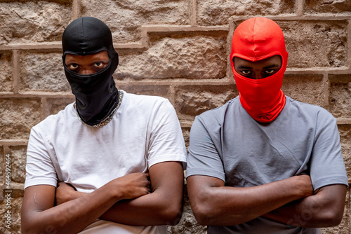 Two afro young men in ski masks in alleyway