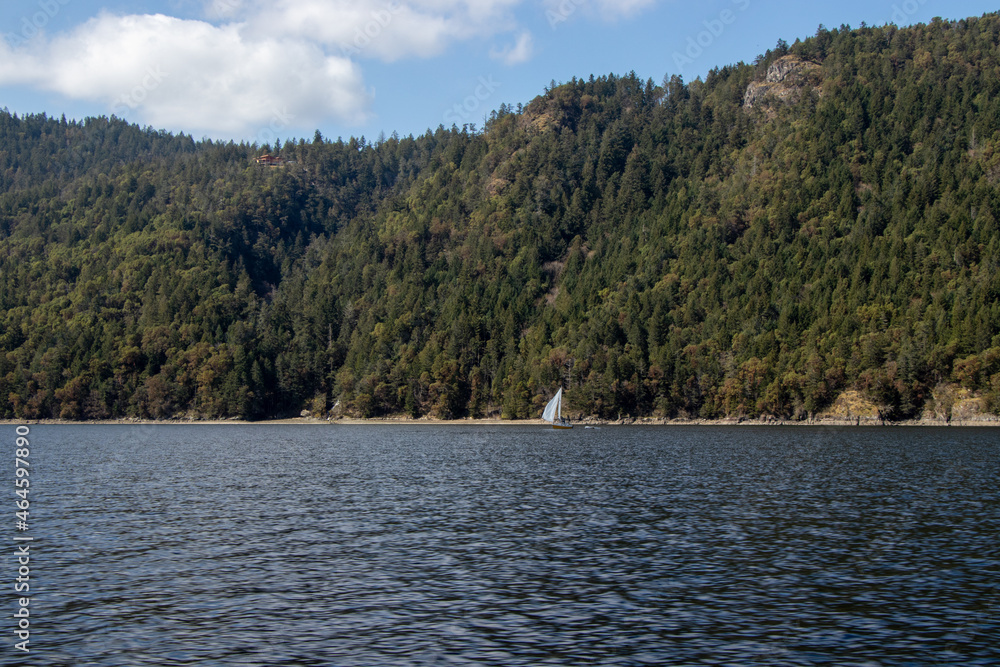 A sailboat in the water on the coast A sailboat in the water on the coast