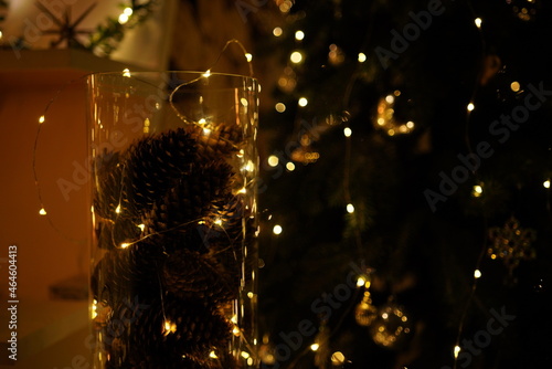 New Year 2021 interior with candles, bulbs and bokeh. Room decorated to christmas celebration. Christmas tree with presents 