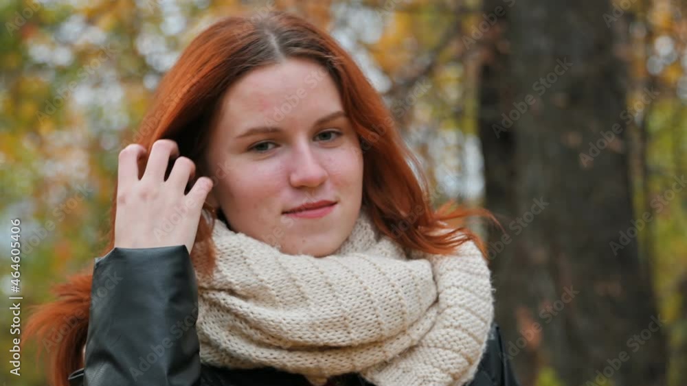 a young girl turns in front of the camera against the background of an autumn yellow park close-up. a young girl turns in front of the camera against the background of an autumn yellow park close-up.