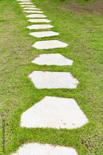 White granite walkway slabs patterned in green lawns at the garden