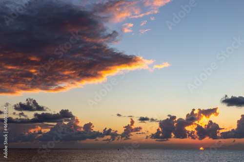  soleil levant au dessus de l'océan avec ciel avec des nuages orangés
