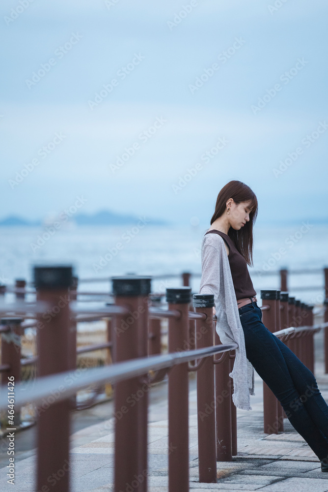 夕暮れの海岸にいる女性