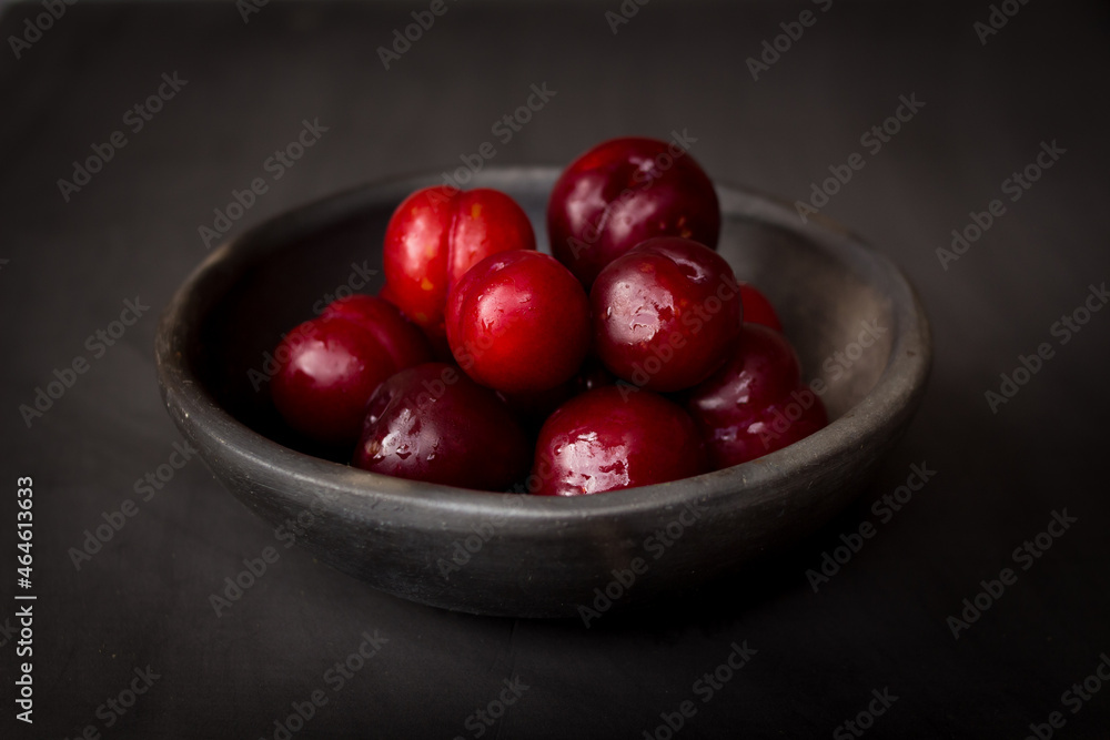 plate of fresh plums on dark background plate of fresh plums on dark background