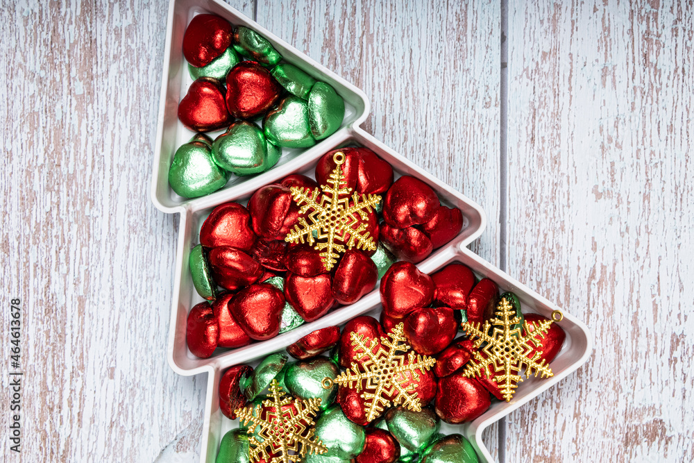 Christmas snack plate with heart shape chocolate candies on wooden background.