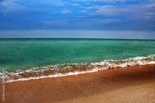 Blue sea wave on a pebble beach.