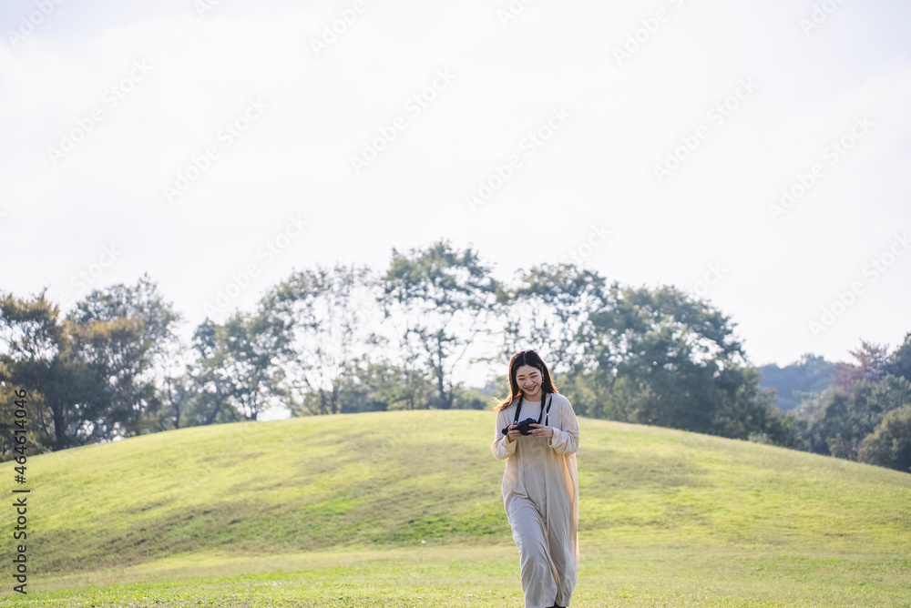 Fototapeta premium 公園を散策するカメラ女子