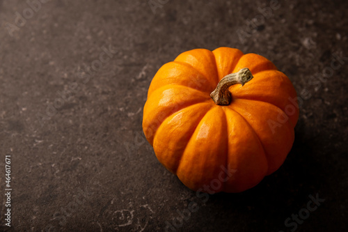 Small orange pumpkin close up. Pumpkins are widely grown for commercial use and as food, aesthetics, and recreational purposes. Much consumed on Thanksgiving Day and Halloween decoration photo