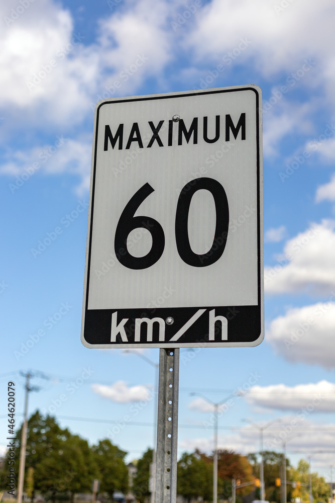 Speed limit road sign in the street, driving 60 km maximum in Ottawa, Canada. Traffic on the road Speed limit road sign in the street, driving 60 km maximum in Ottawa, Canada. Traffic on the road