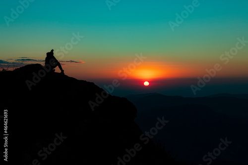 A person admiring the Sunset over the Mountain