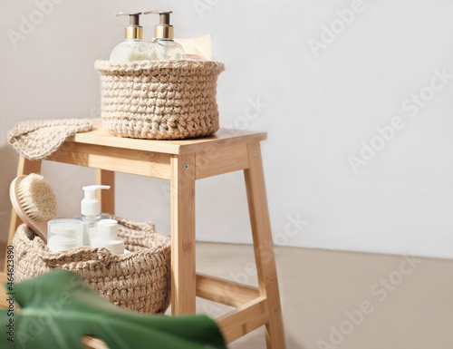 knit jute baskets with toiletries on light wooden A stand in a room. natural eco interior design, boho or country style.copy space.