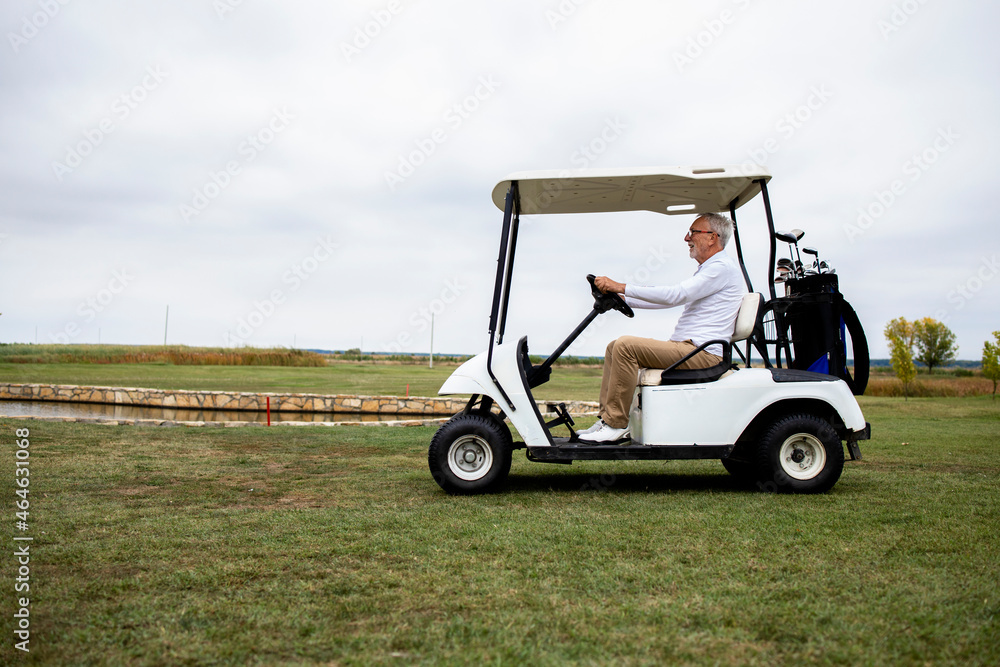 Shot of wealthy senior man driving golf car to the green zone to continue golfing.