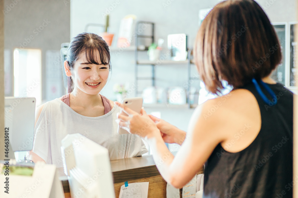 受付でスマホを出す女性
受付でスマホを出す女性