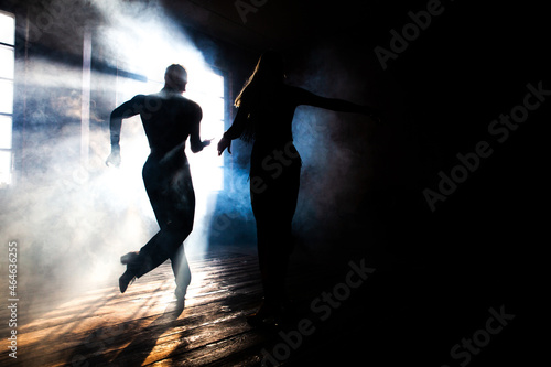 Couple of two professional ballroom dancers is dancing on loft studio. Beautiful art performance with heavy smoke. Sport life concept. Passion and emotional dance. © Vadym