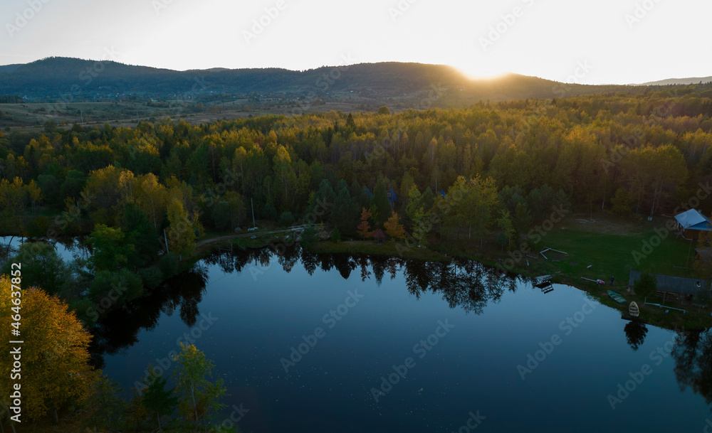 Beautiful Sunset over calm colorful Lake. Sunset landscape on the lake with the falling hot sun. Aerial view of lake.