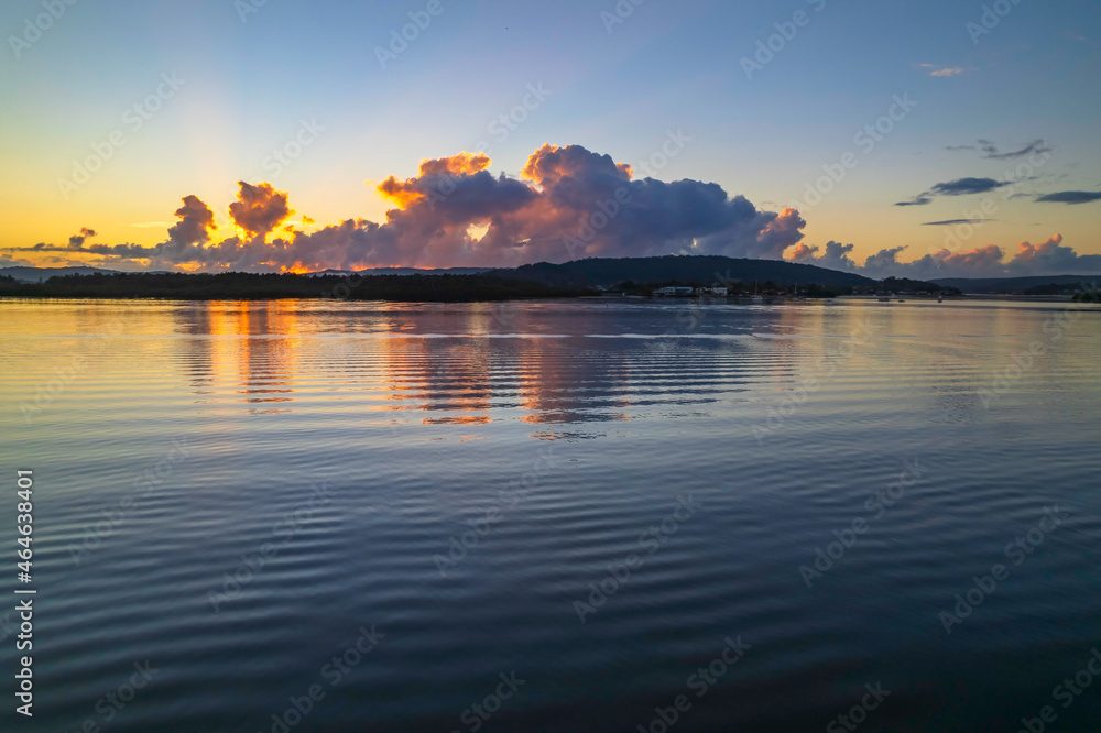 Naklejka premium Aerial sunrise over the bay with clouds and reflections