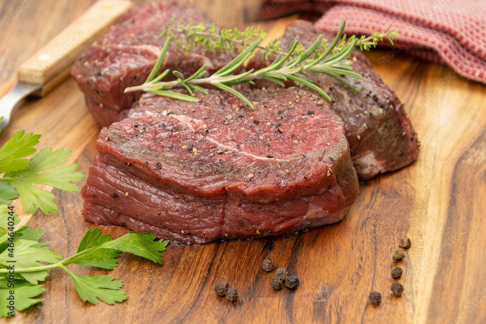 tournedos de boeuf cru sur une planche à découper	