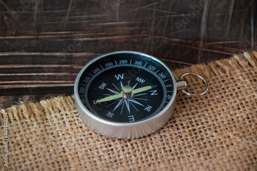 Compass on burlap. Geographical background close-up. Tourism, geography, path, direction