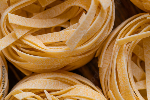 Homemade fettuccine pasta folded in the shape of a nest. Home cooking with ingredients for homemade traditional Italian fettuccine pasta.