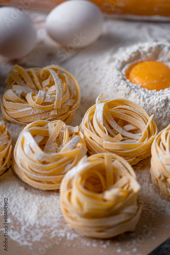 Homemade fettuccine pasta folded in the shape of a nest. Home cooking with ingredients for homemade traditional Italian fettuccine pasta.