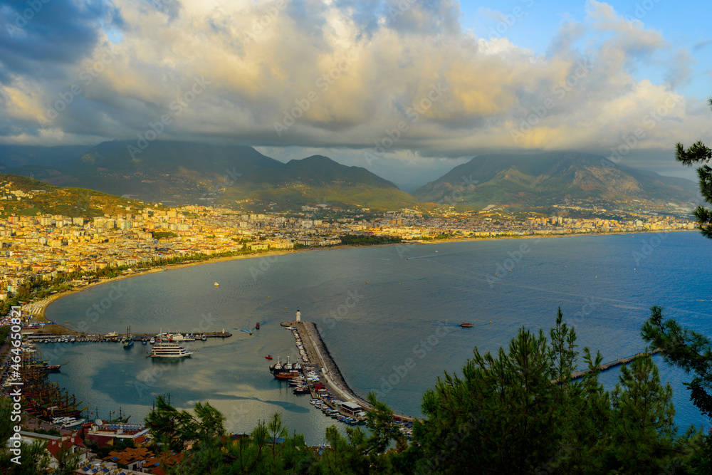 Obraz premium view of Alanya and the port illuminated by the setting sun with colorful clouds in autumn