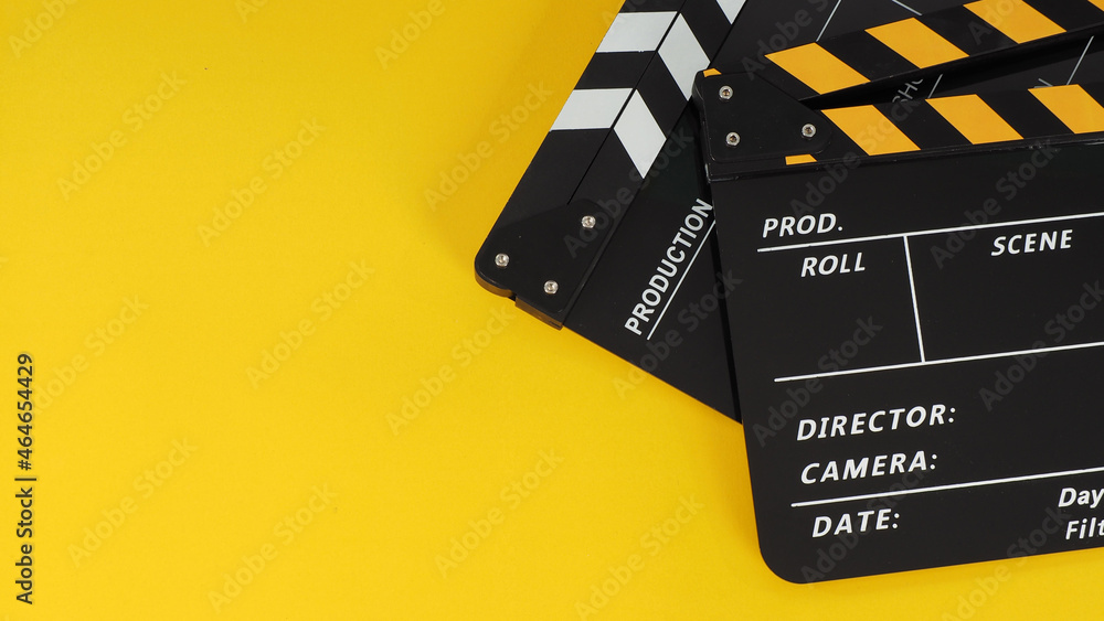 Two Black and yellow Clapper board or movie slate on yellow background.