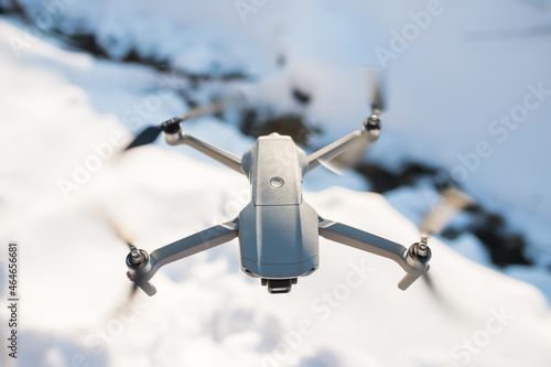 The drone is flying over the ground in the sky. take pictures from the sky in winter. the drone lands on the ground