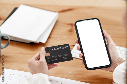 Online payment, woman hands holding a credit card and using smart phone for online shopping.