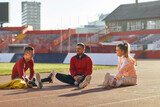 Group of three athletes stretching together