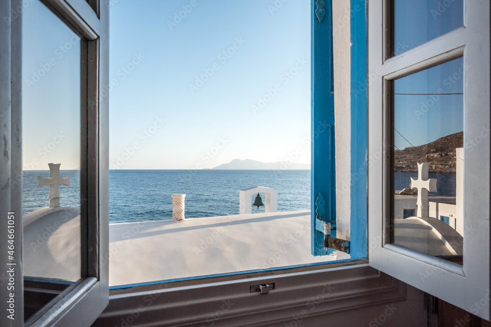 Blick durch ein offenes Fenster auf eine Kirche, das Meer und eine griechische Insel vor Lefkos, Karpathos, Griechenland. Vorlage, Textfreiraum, Werbung, Reisen.