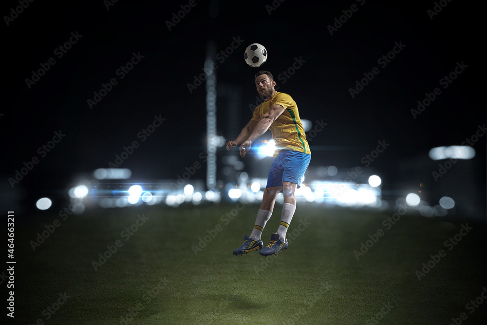 A professional soccer player demonstrates complex moves in the soccer arena wearing a yellow jersey and blue shorts.