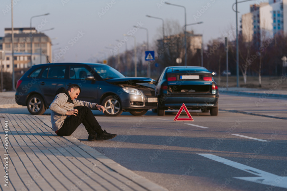 Man sitting on the road after traffic collision