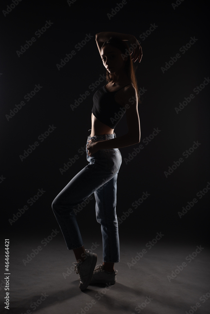 Silhouette of girl posing in studio while holding posture
