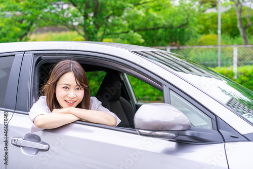 運転席から顔を出す若い女性 © maroke