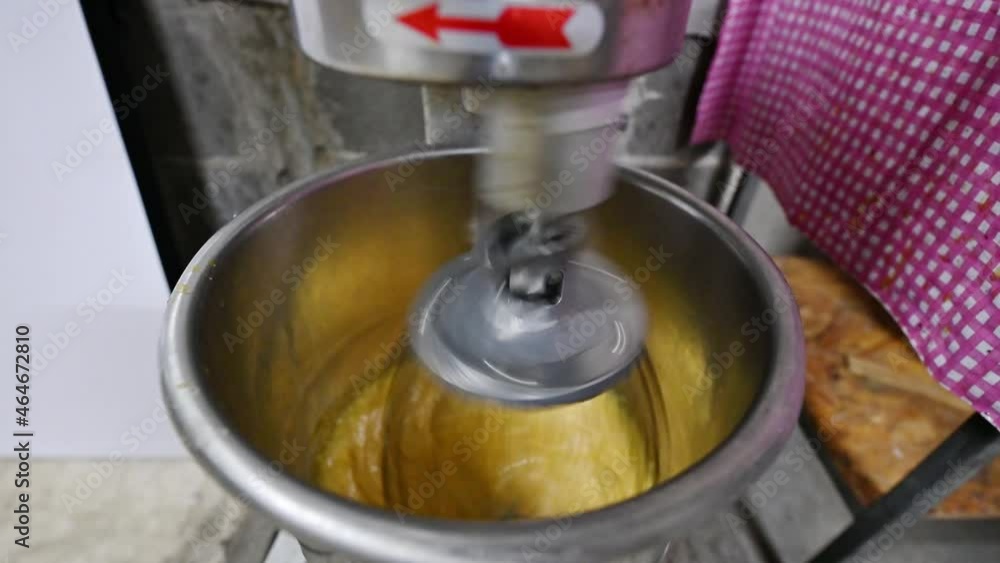 Electric stainless hand mixer with mixing yolk in bowl Electric stainless hand mixer with mixing yolk in bowl
