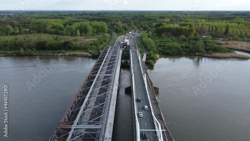  Temse bridge over the river Scheldt seen from above with traffic and cars driving on both side of the road near green trees in summer. Drone aerial birds eye view shot photo