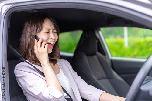 スマホを使いながら車を運転する女性 © maroke