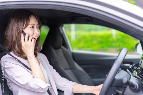 スマホを使いながら車を運転する女性