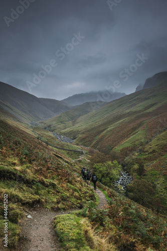 Hikers walk through hills in Lake District