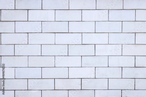 The wall is lined with light beige tiles. Geometric rectangular texture.