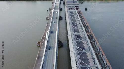 Temse bridge over the river Scheldt seen from above with traffic and cars driving on both side of the road near green trees in summer. Drone aerial bird eye view revealing Temse town photo