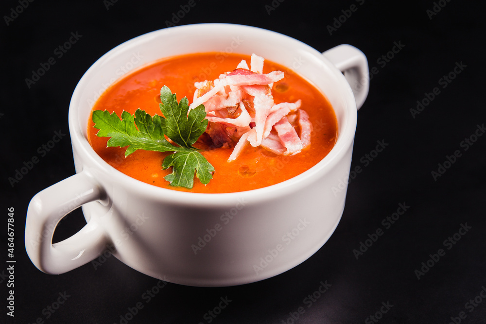 Tomato soup with bacon in white mask on a black background Tomato soup with bacon in white mask on a black background