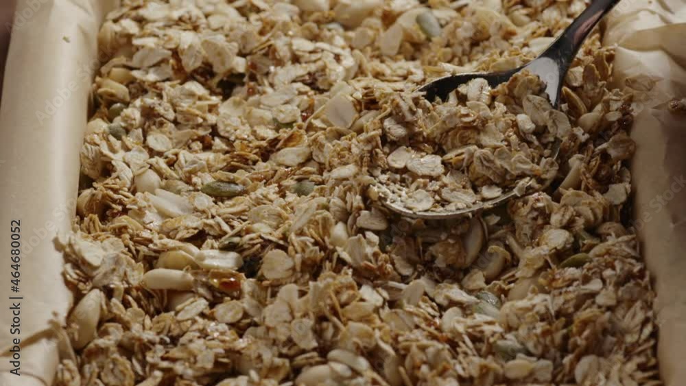 Slow motion making homemade granola mixing oats with nuts and seeds Slow motion making homemade granola mixing oats with nuts and seeds