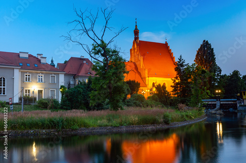Panorama of Brick Gothic Bydgoszcz Cathedral with reflection in Brda River at night, Bydgoszcz, Poland