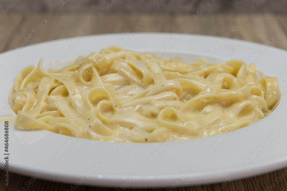 Cheesy plate of pasta alfredo served as a perfect Italian lunch meal