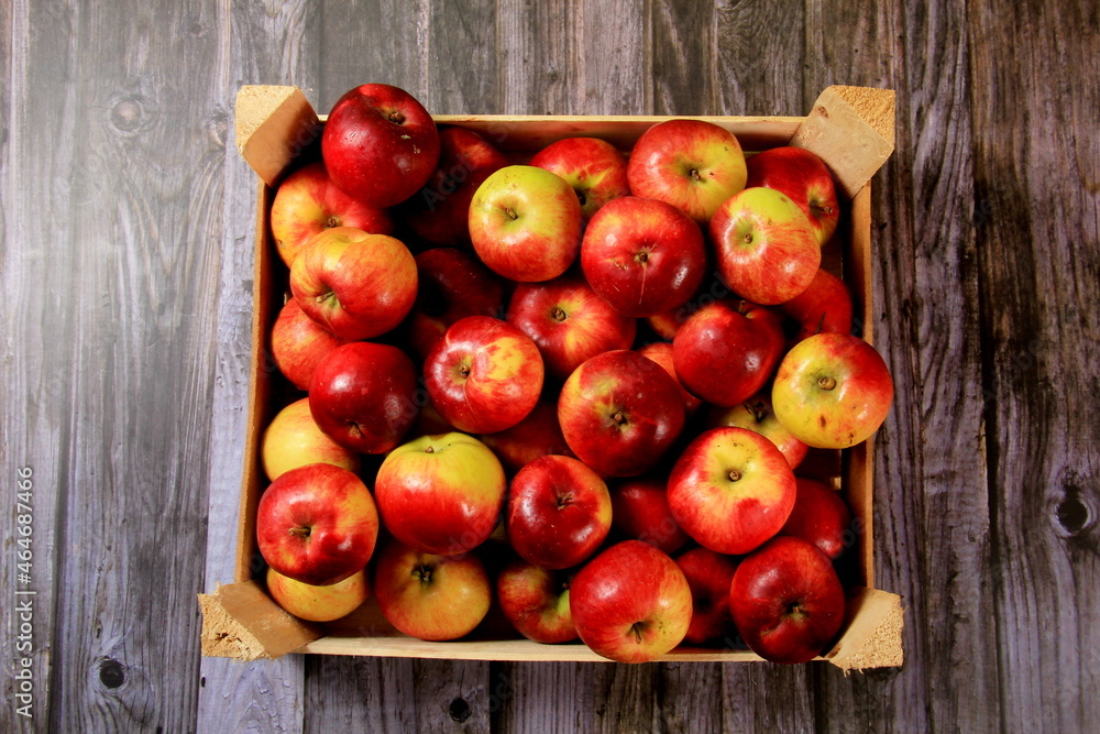 Red apples in a wooden box on a wooden board background. Copy space Red apples in a wooden box on a wooden board background. Copy space