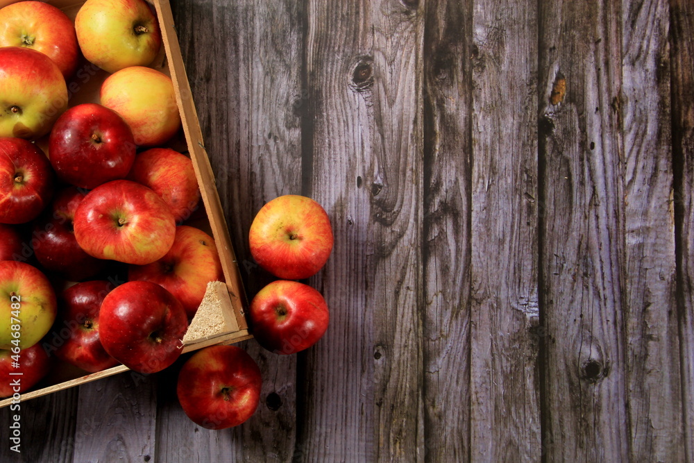 Red apples in a wooden box on a wooden board background. Copy space Red apples in a wooden box on a wooden board background. Copy space