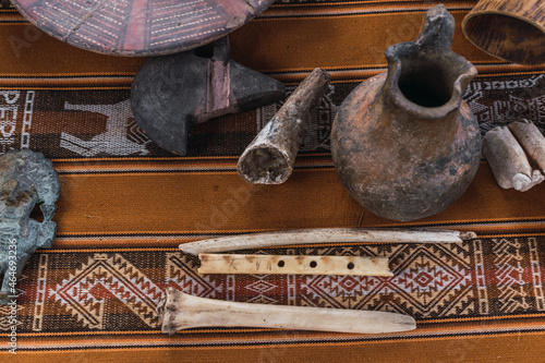 ceramics in the incas on a traditional table with traditional blanket queros plates, glasses and cultural basijas from the Andes of Peru photo